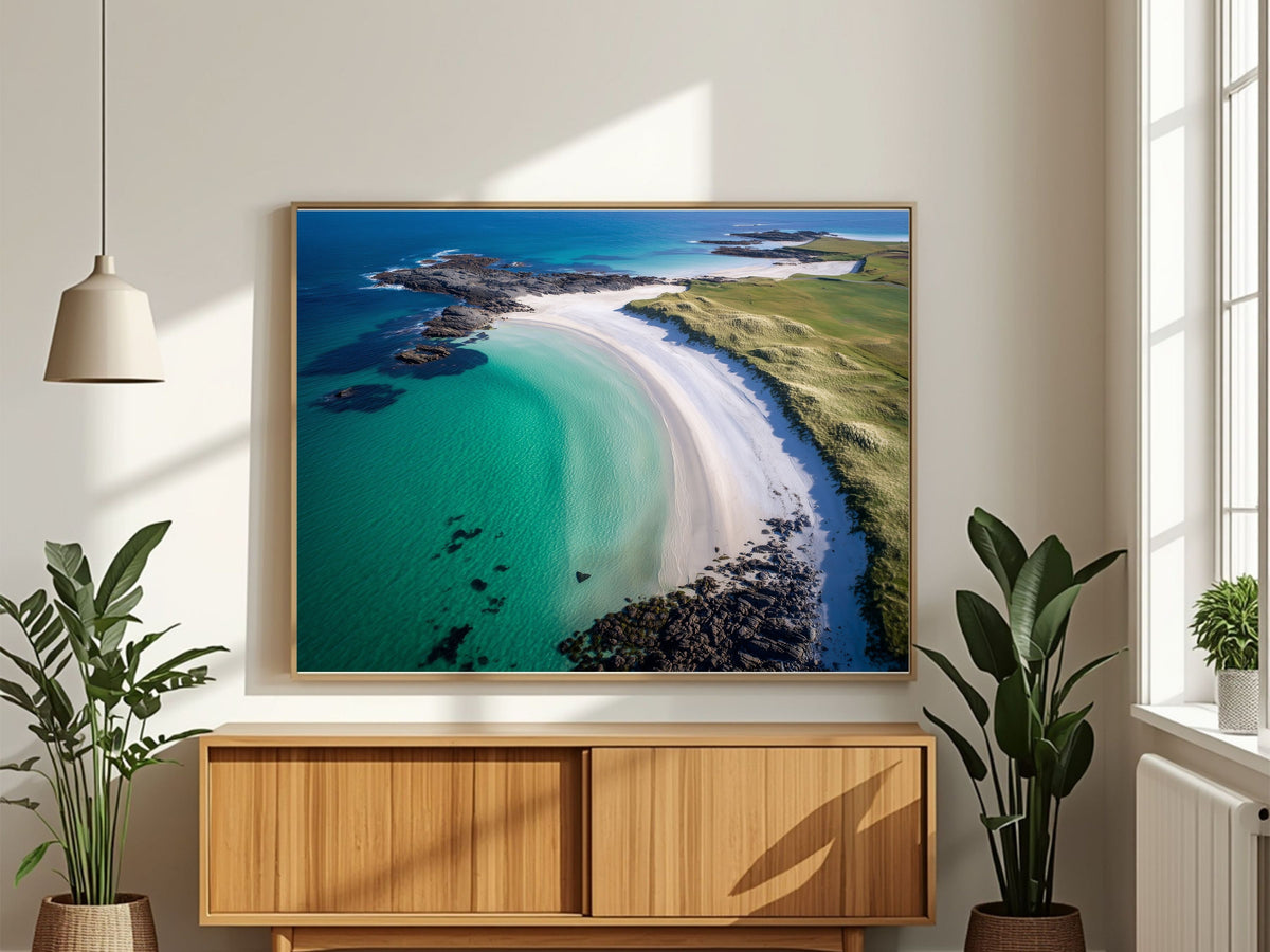 Turquoise bay and white shell-sand beach from the air, framed in light wood above a wooden sideboard