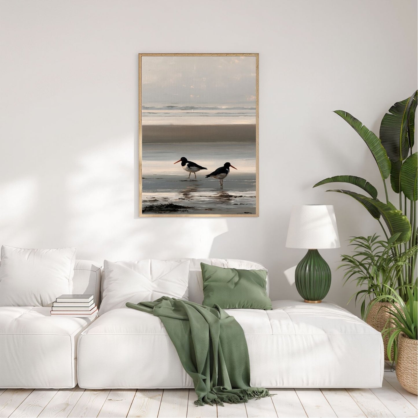 Two oystercatchers at low water, framed in pale wood above a white sofa in a bright plant-filled living room