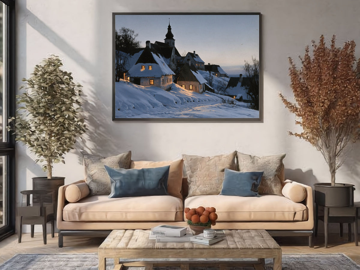 Snowy village at dusk print in a dark frame above a cream sofa in a bright living room